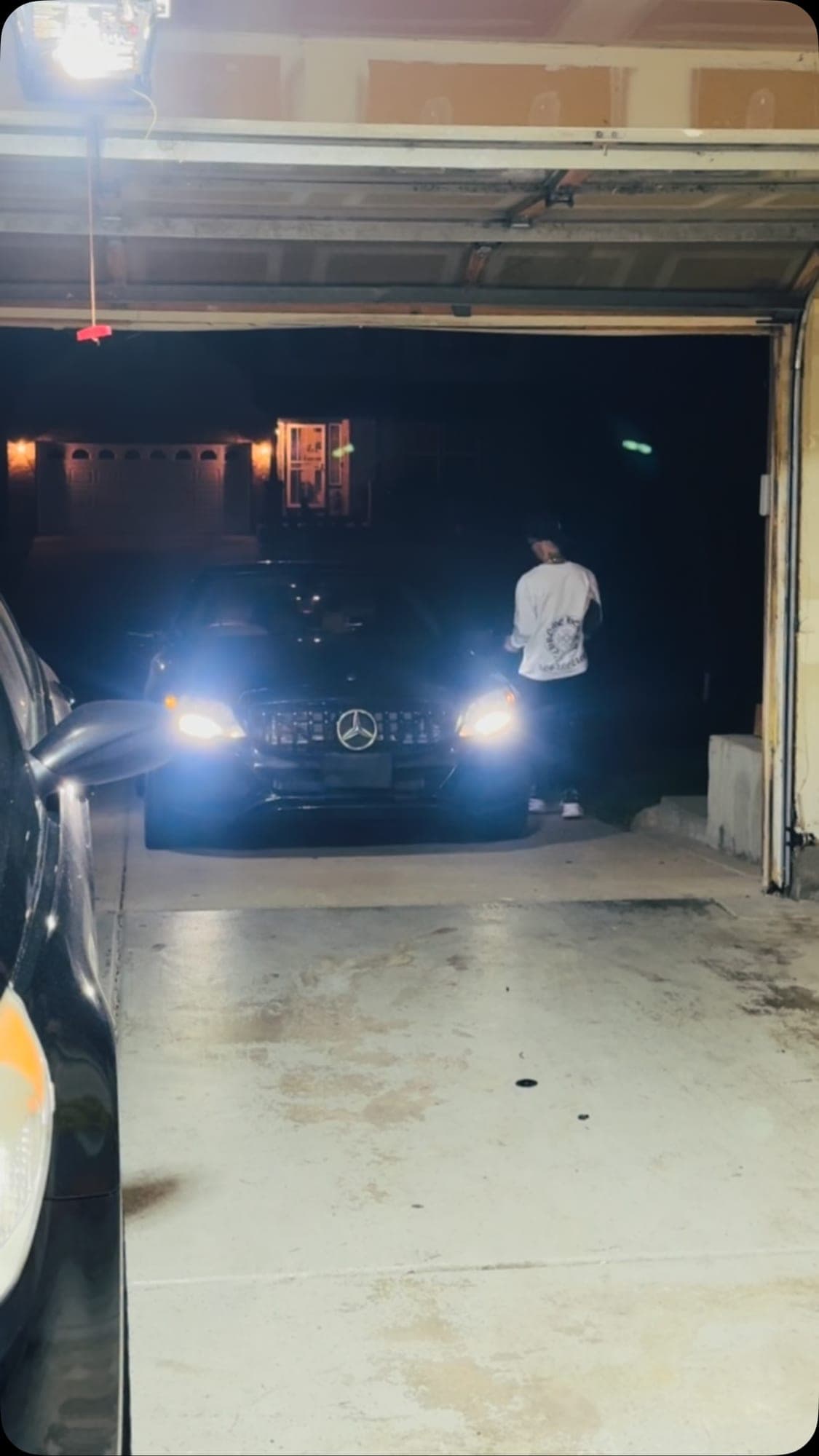 Mercedes con los faros encendidos dentro de un garaje de noche